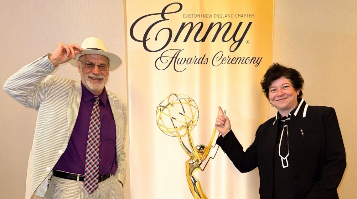 Tom Bell and Annella Linton in front of the 2026 New England Emmys banner in Boston.