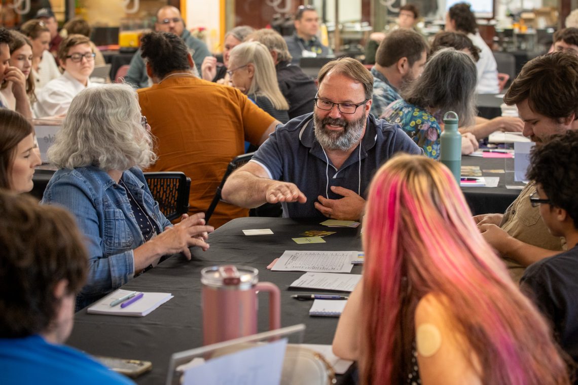 Delegates talk through ideas during a small-group discussion at their table.