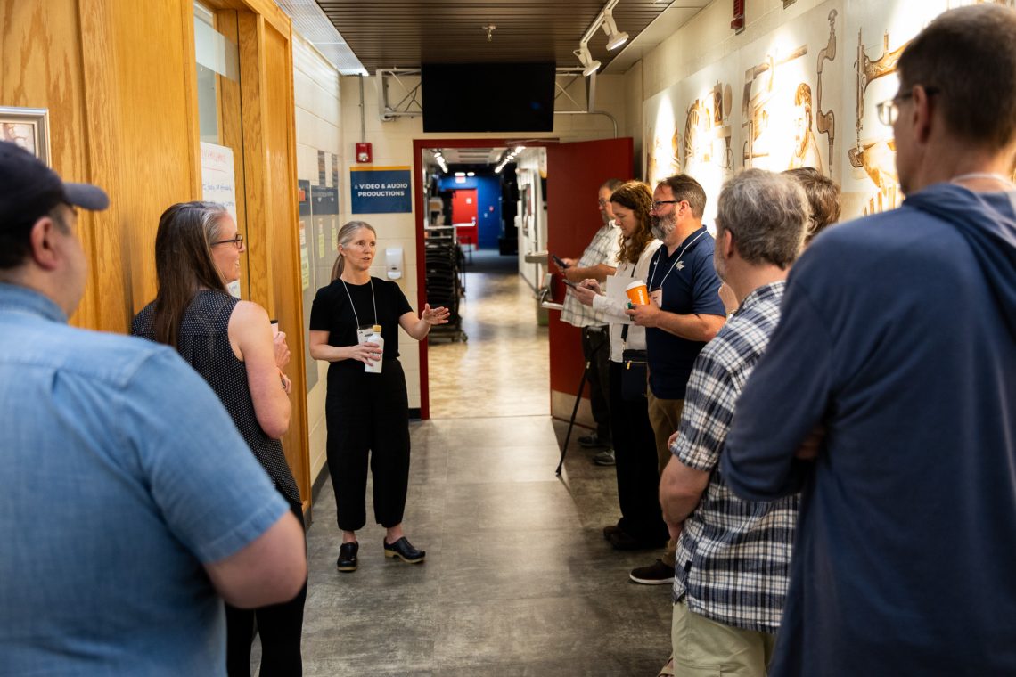 Jennifer Chace, assistant director of CEPARE, speaks with a group of moderators gathered in a hallway.