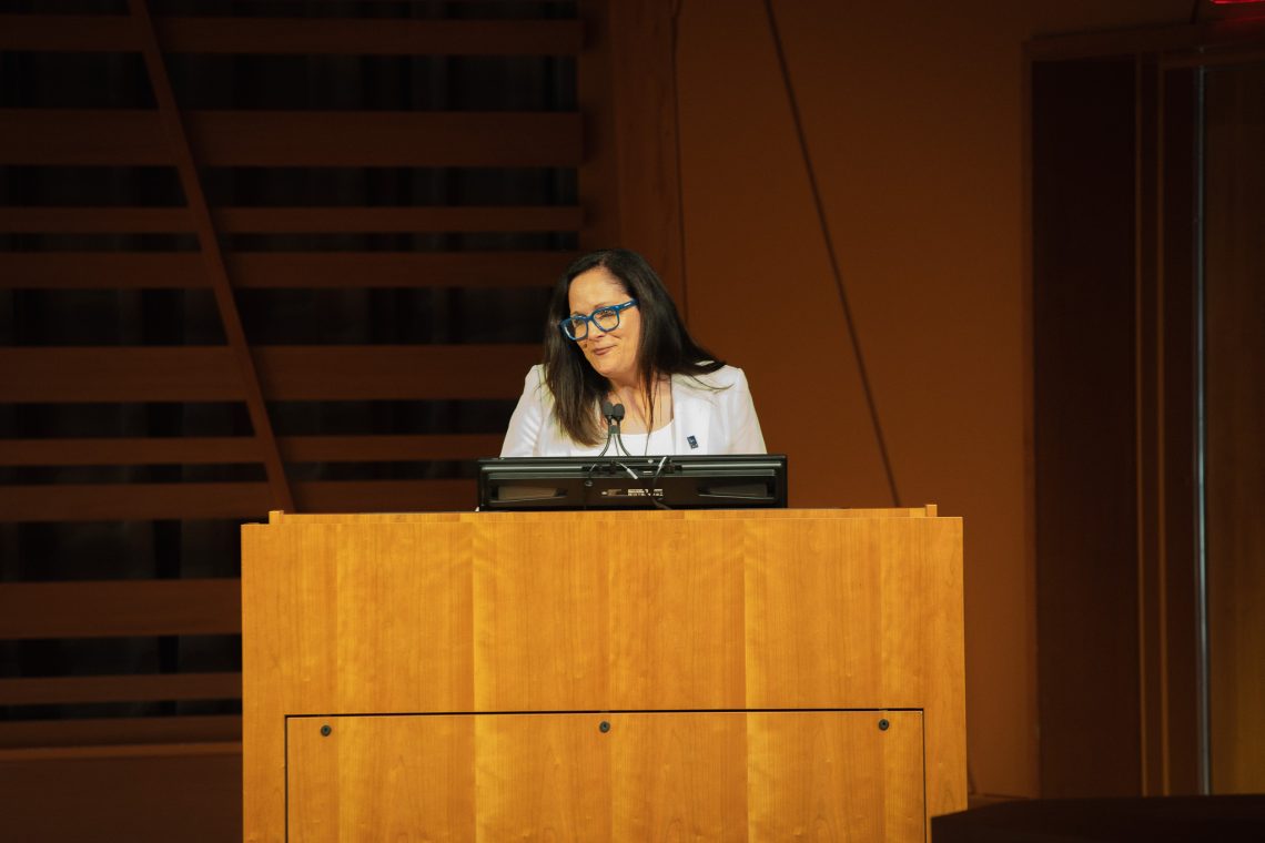 USM President Jacqueline Edmondson speaks from a podium at USM's Crewe Center for the Arts.