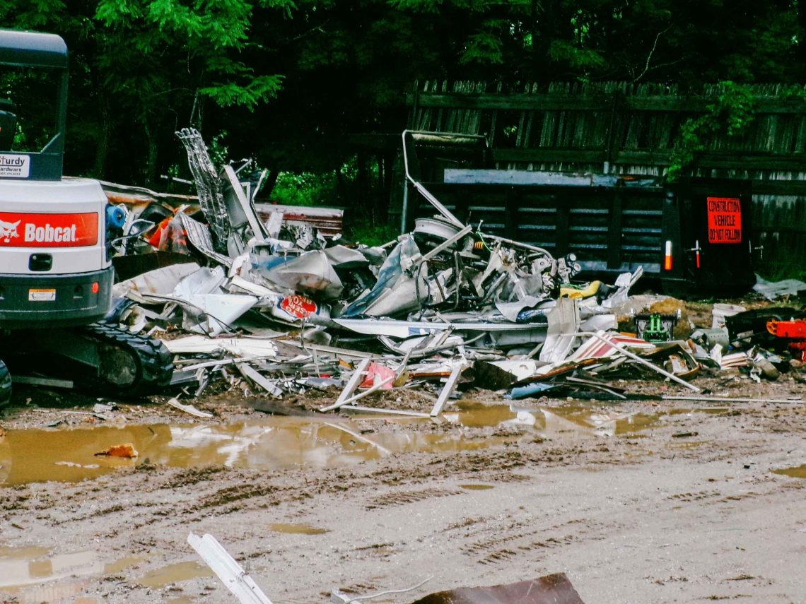 A pile of scrap metal and debris on a lot.