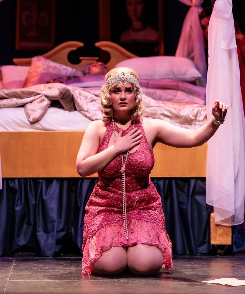 Actress from Gianni Schicchi on her knees singing on stage.