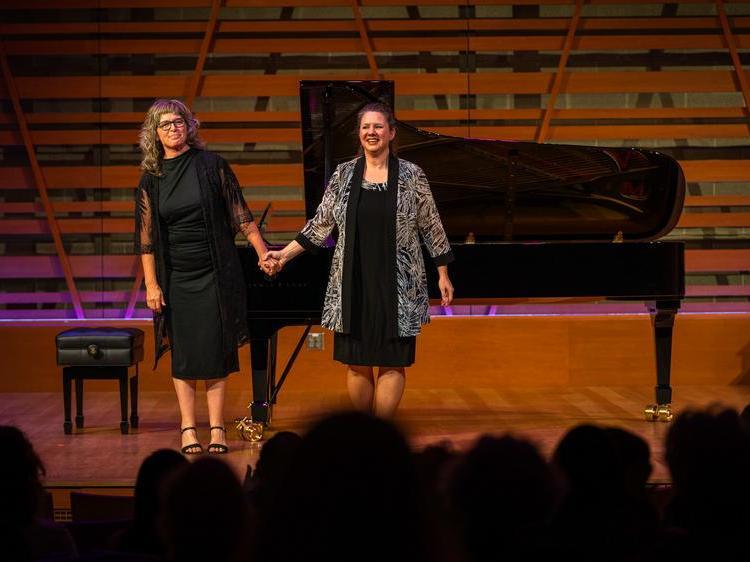 Pianist and solo singer joined hands for applause from audience.