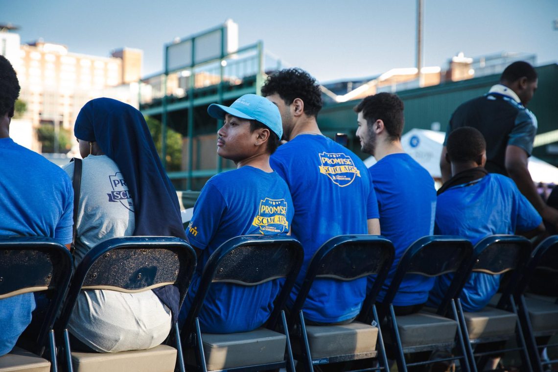 USM Promise Scholars sit together in Promise Scholars t-shirts at Fitzpatrick Stadium.