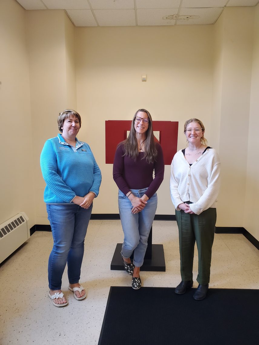 Three OT students standing in hall.