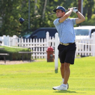 A golfer steps up up to his first tee at the 2024 Husky Golf Classic and lets it rip.