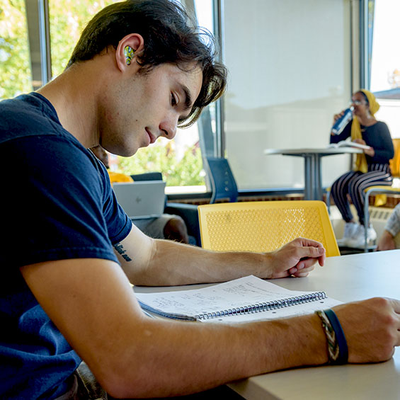 A student studies while seated at a table in one of our student lounges.