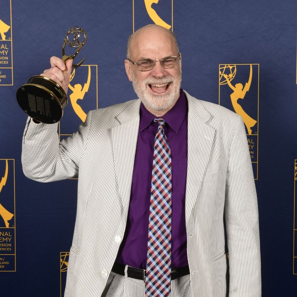 Tom Bell holding his New England Emmy for "An Extraordinary Place".
