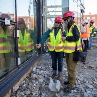 During a tour of the Crewe Center, visitors from Maine Audubon feel the acid-etched markings on the windows, which make the glass visible to birds.