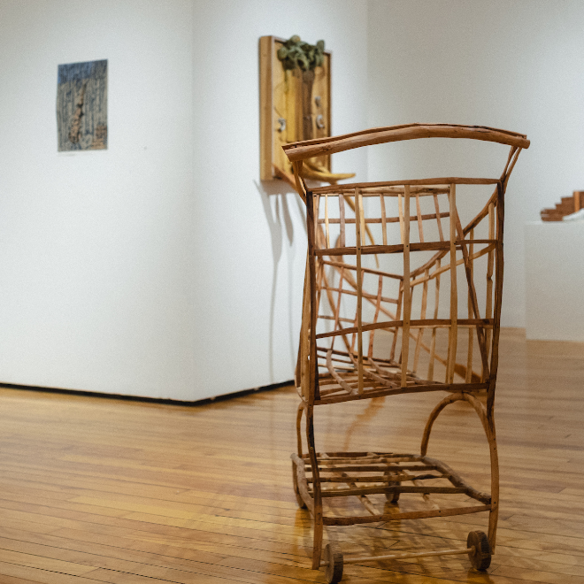 Artist Lin Lisberger exhibition, featuring sculpture of a shopping cart made from assorted hardwood.