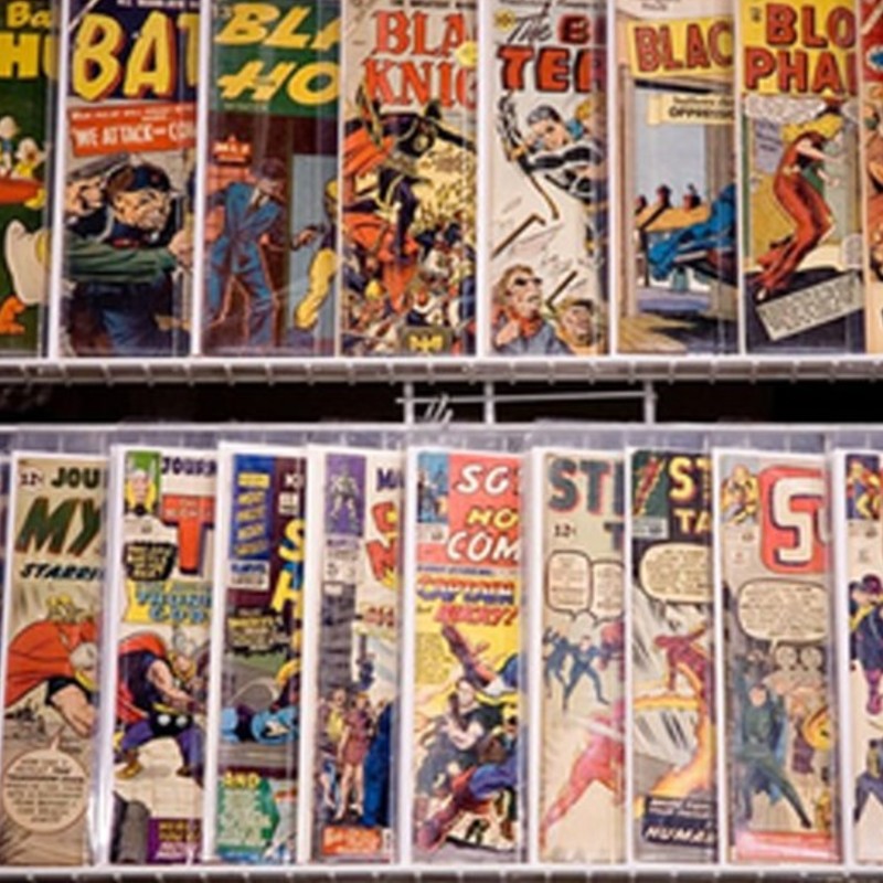 A shelf of different comic books on display