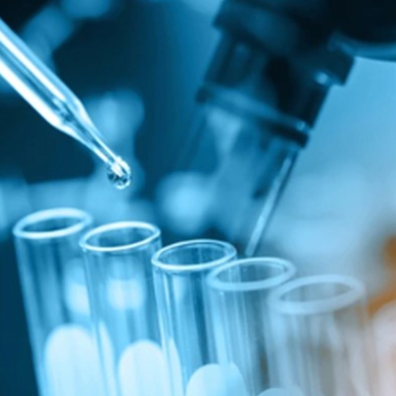 A drop of liquid is added to a glass vial in a lab