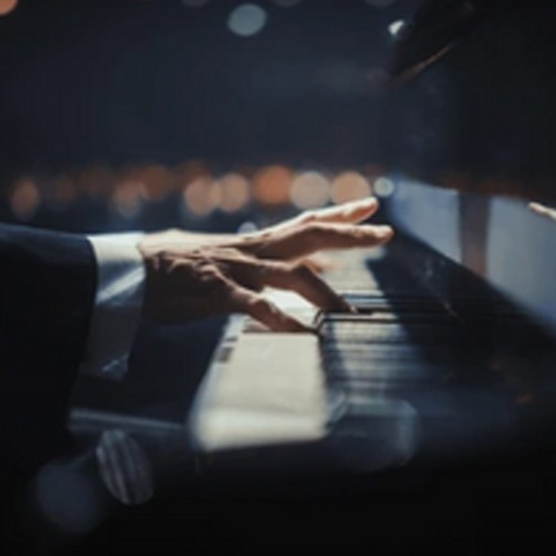 Close up of a hand playing piano