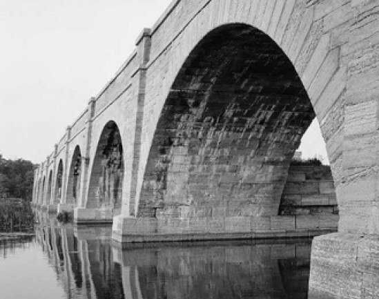 A stone bridge spanning a canal.