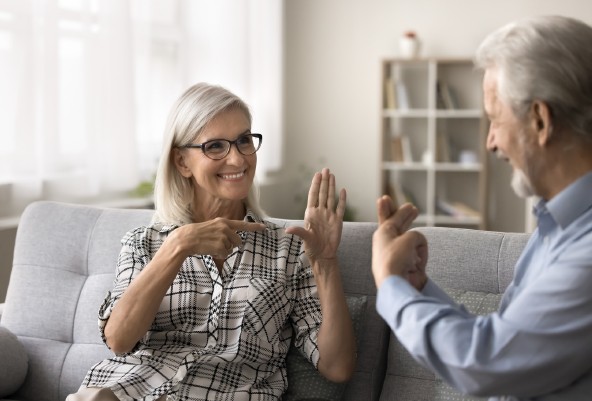 Two adults conversing in sign language.