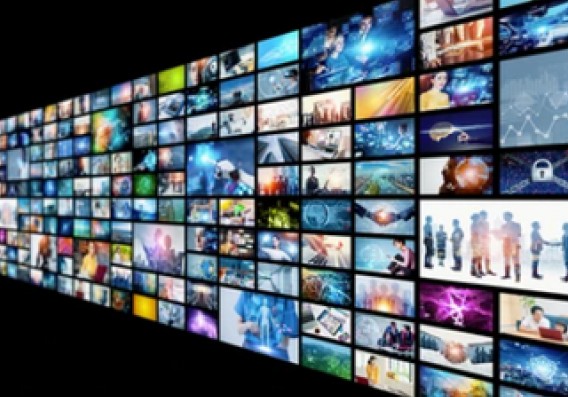 A wall of television screens lit up with a variety of pictures.