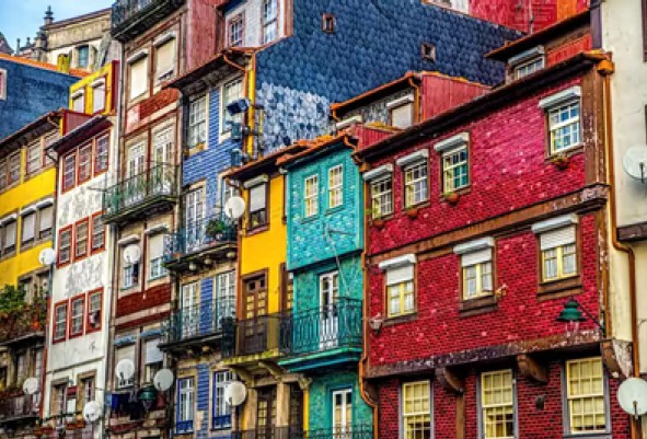 A multi-colored Portugal building with windows and balconies.