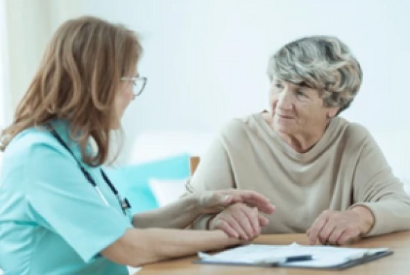 A physician talks with a patient