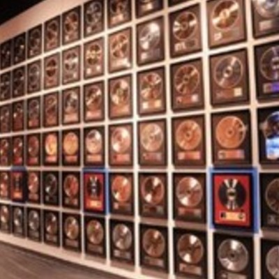 Country Music Hall of Fame displaying many framed gold and platinum records, some with CDs and plaques inside, others with just plaques.