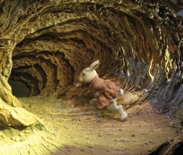 a white rabbit in a brown coat enters a cave in this animated picture