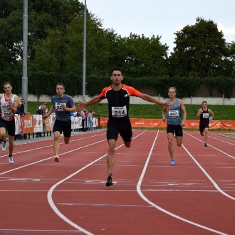Runners crossing the finish line on a track.