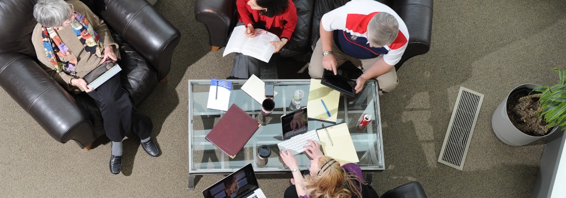 Overhead view of small group of adults working together in casual seating