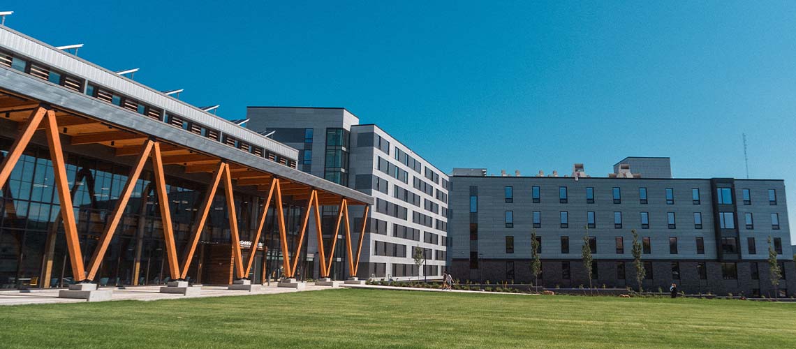 On the left, alternating diagonal mass timbers frame the portico of our new Career & Student Success Center. On the right, two wings of our Portland Commons residence hall are visible.