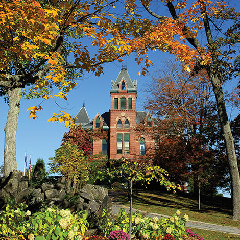 Corthell Hall surrounded by bright foliage on a bright autumn day.