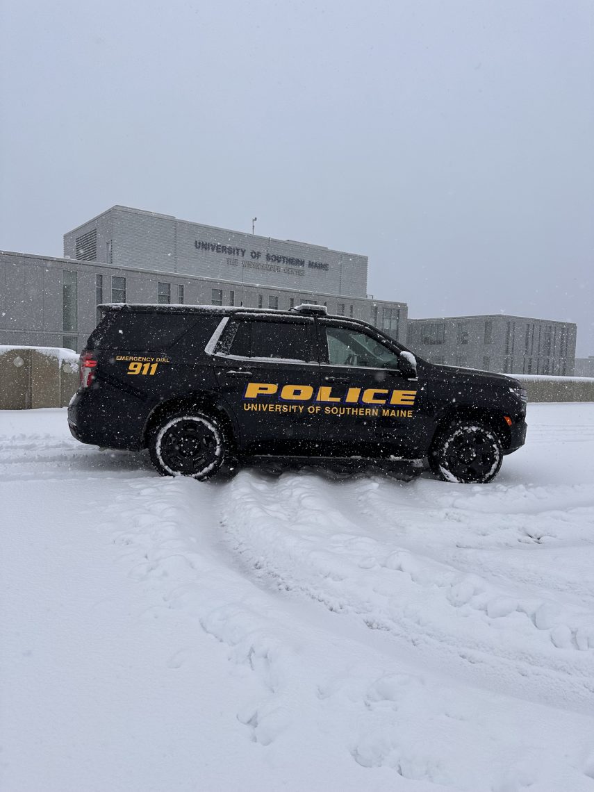 New black Tahoe police cruiser in front of McGoldrick Student Center on a snowy day.