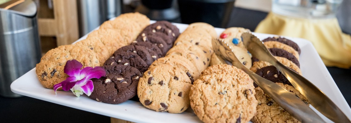 A selection of cookies on a plate with metal tongs