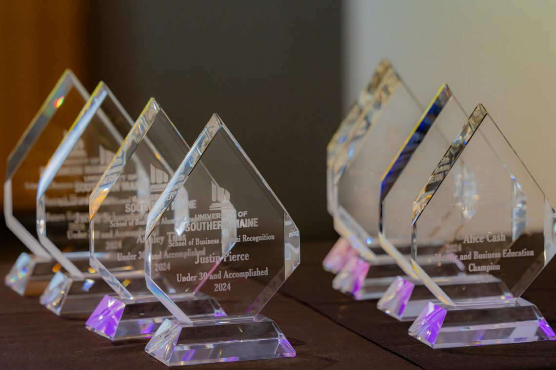 Images of 8 glass award trophies. 