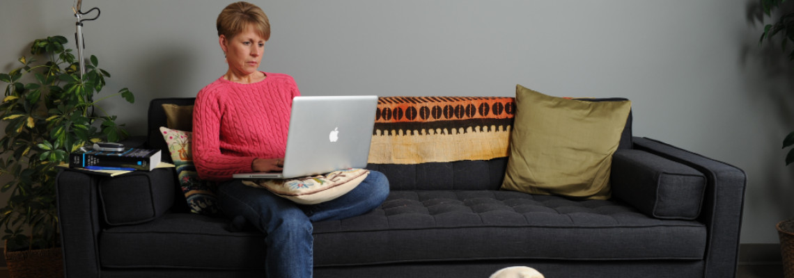 Student sitting on couch typing on laptop