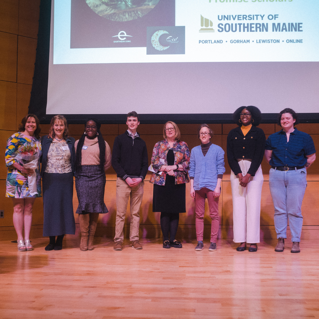 8 people standing on stage