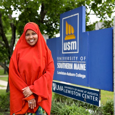 Student stand next to the USM LAC campus sign.