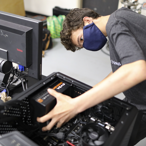 Camper holding open desktop PC while installing parts.