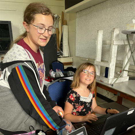 Two campers working on laptops at a LEGO robotics camp.