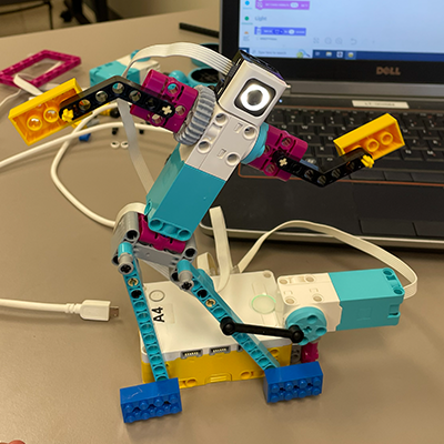 SPIKE robot dancing in front of a laptop