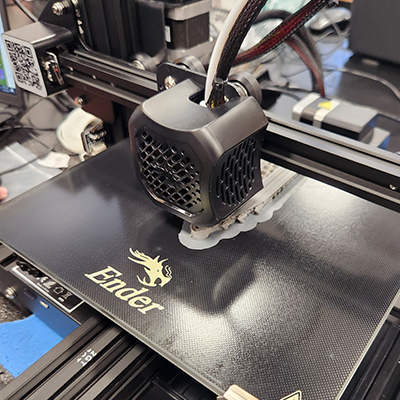 Up-close image of an Ender 3D Printer in the middle of printing an object.