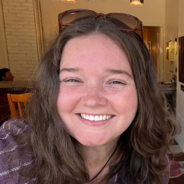 Smiling photo of Kelly Maguire with sunglasses on top of her head