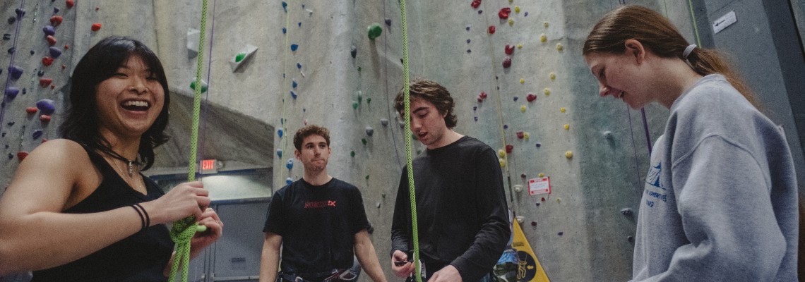 Four USM students having fun in a climbing gym.