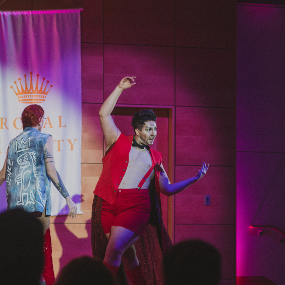 Drag artist in red vest performing