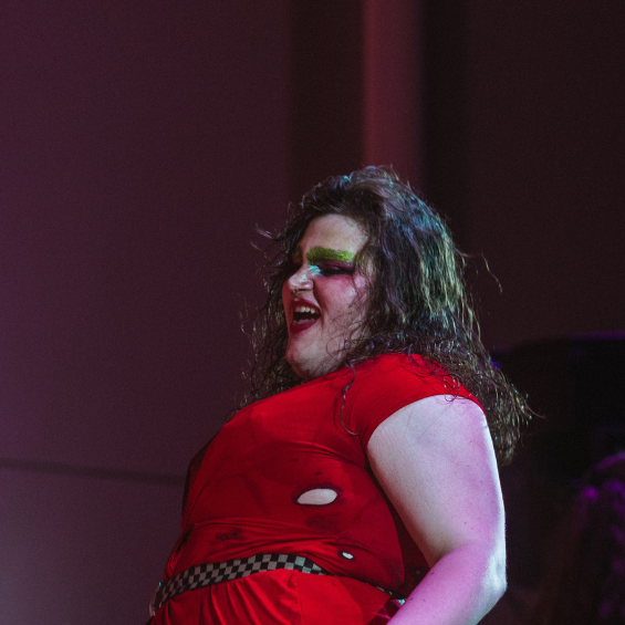 Drag artist in red dress performing