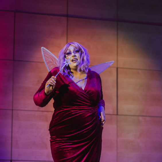 Drag artist in Shrek Fairy Godmother outfit performing