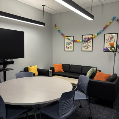 Room with couches, tv, and rainbow paper chain