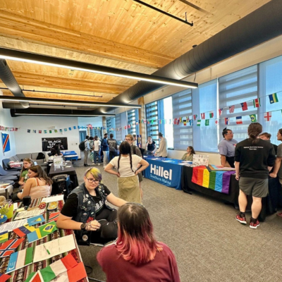 Large open room with groups tabling and various flags hanging on the wall
