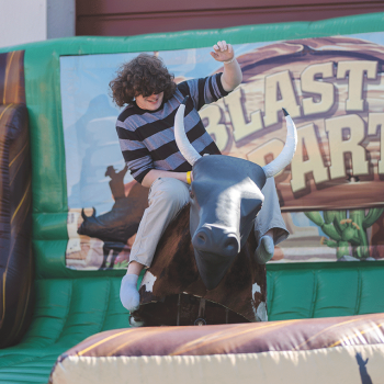 A student riding a mechanical bull at Octoberfest