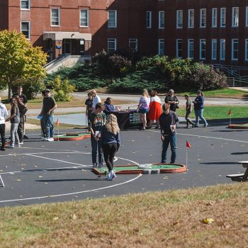 Students and friends playing miniature golf at Octoberfest.