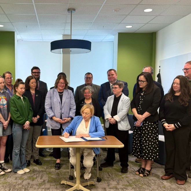 Governor Janet Mills signs bill regarding teacher pay surrounded students, legislators, and USM faculty