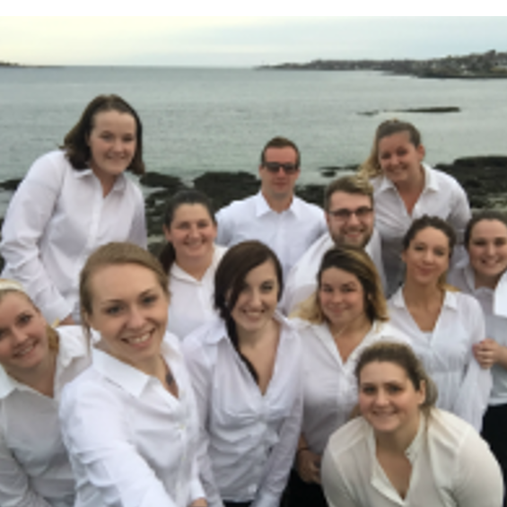Group of students in white shirts by the ocean