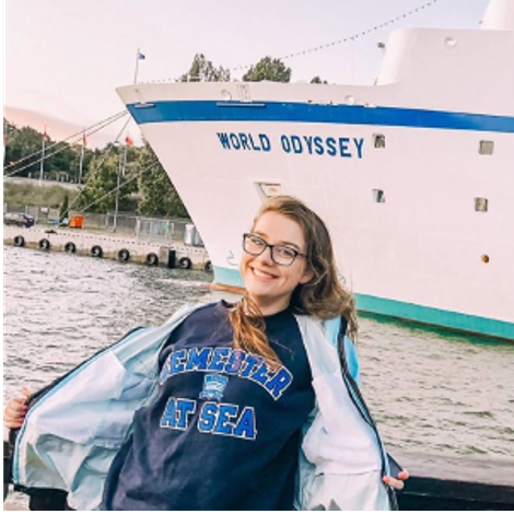 Hannah Daigle enjoying her Semester at Sea program in front of a ship, the World Odyssey